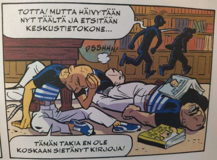 Valokuva sarjakuvan ruudusta, jossa taustalla Pikon ja Fantasion siluetit säntäävät karkuun kirjahyllyjen ohitse. Piko sanoo Totta, mutta häivytään nyt täältä ja etsitään keskustietokone. Etualalla makaa pökertyneitä korstoja. Kaksi on taju kankaalla ja heidän päällään on pari kirjaa. Toinen kirjoista on nimeltään Inspecteur Bayard ja toinen Le club des amis. Kolmas korsto on tajuissaan, mutta pitelee päätään ja sanoo Tämän takia en ole koskaan sietänyt kirjoja.